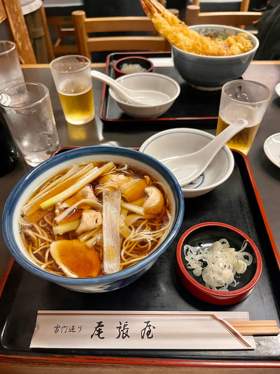 A bowl of soba on a lacquered tray at Owariya, with a bowl of shrimp tempura soba behind it